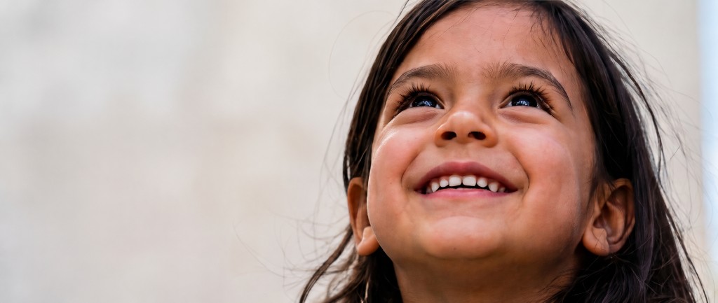 Una niña sonríe y mira hacia el futuro